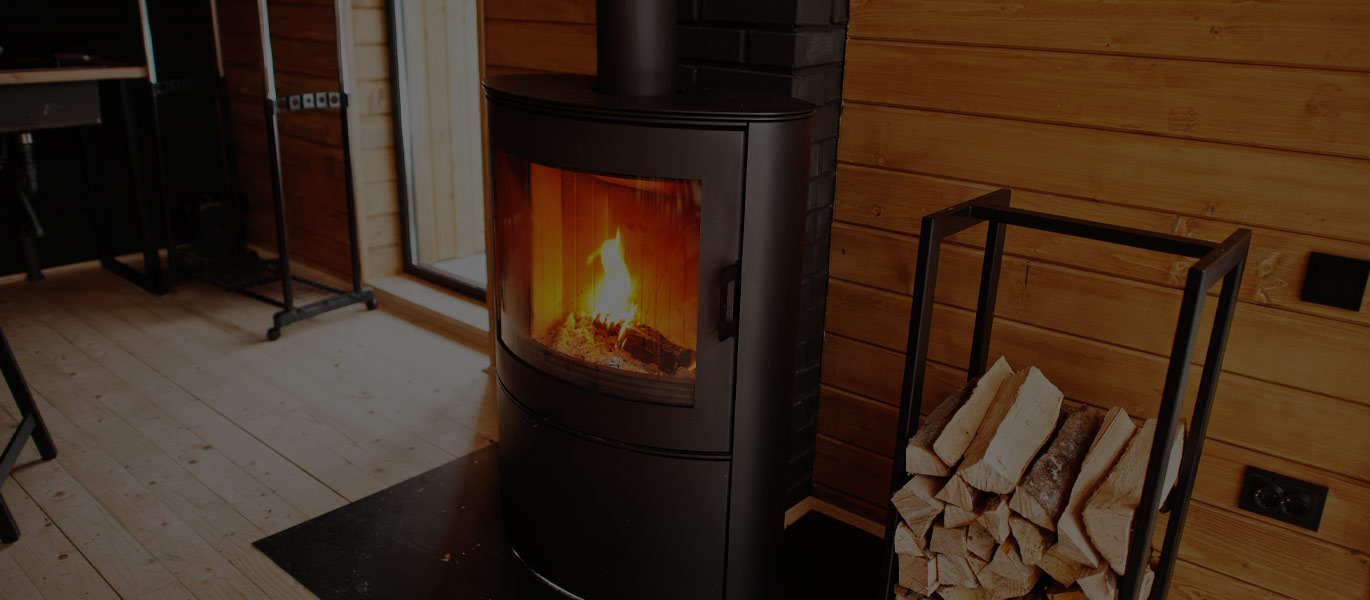 A stove alight in a timber-clad room